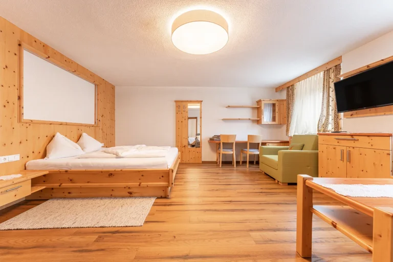 Helles Schlafzimmer im Familienzimmer mit massivem Zirbenbett und Holzvertäfelung, Gasthof Sagritzer Wirt Kärnten