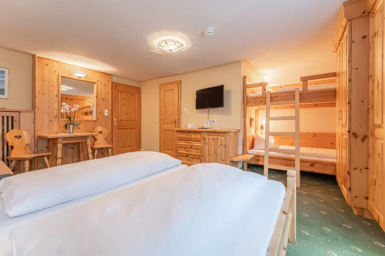 Familienzimmer mit Doppelbett und Stockbett für Kinder, traditionelle Holzeinrichtung im Sagritzer Wirt, Urlaub im Nationalpark Hohe Tauern