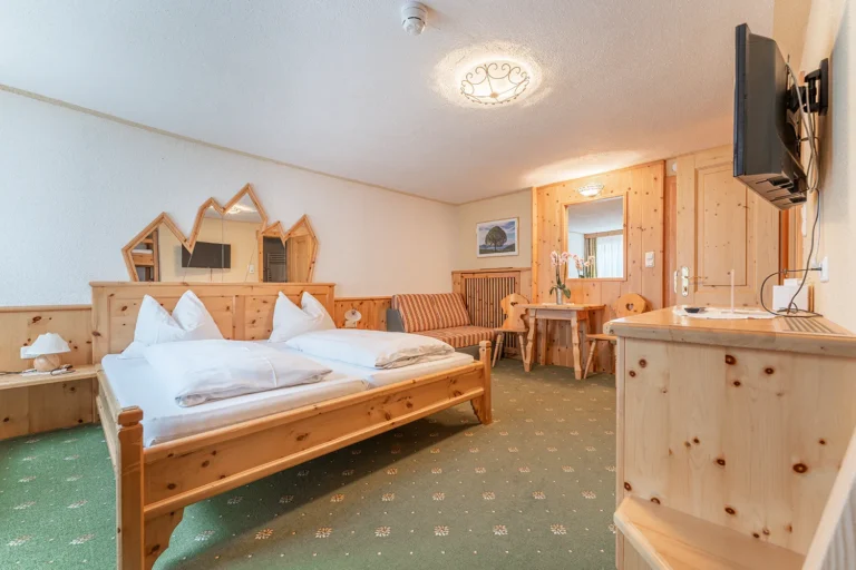 Familienzimmer mit Doppelbett und Stockbett für Kinder, traditionelle Holzeinrichtung im Sagritzer Wirt, Urlaub im Nationalpark Hohe Tauern