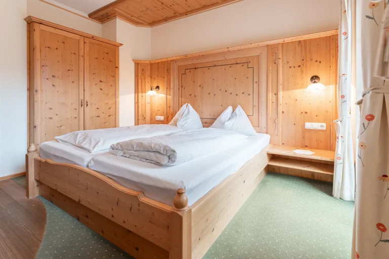Helles Doppelzimmer mit Zirbenholz-Einrichtung und gemütlichem Doppelbett im Gasthof Sagritzer Wirt, Großkirchheim im Mölltal