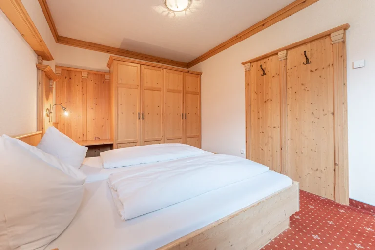 Helles Schlafzimmer mit Doppelbett und großem Einbauschrank in der Ferienwohnung Turm beim Sagritzer Wirt, Mölltal Kärnten
