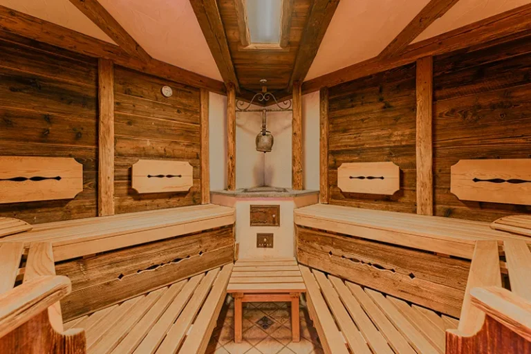 Innenansicht der Holzsauna mit Sitzbänken und Ofenecke im Sagritzer Wirt